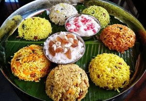 A colorful banana‑leaf platter showcasing an assortment of flavored rice mounds—lemon rice, tamarind rice, coconut rice, vegetable pulao, and curd rice topped with pomegranate—perfectly styled by babyshower catering services near me in Bangalore.